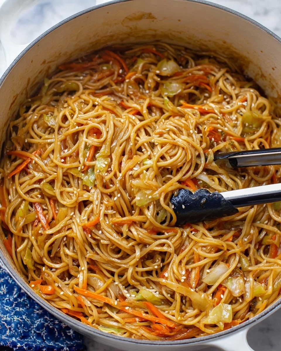 A large white pot filled with long, thin noodles mixed with orange carrot strips and light green cabbage pieces, all coated in a shiny brown sauce. On top of the noodles, small white sesame seeds are scattered. Black and silver tongs are lifting a portion of the noodles, showing their soft texture and mix of vegetables. The pot sits on a white marbled surface with a small part of a blue and white cloth peeking out. photo taken with an iphone --ar 4:5 --v 7