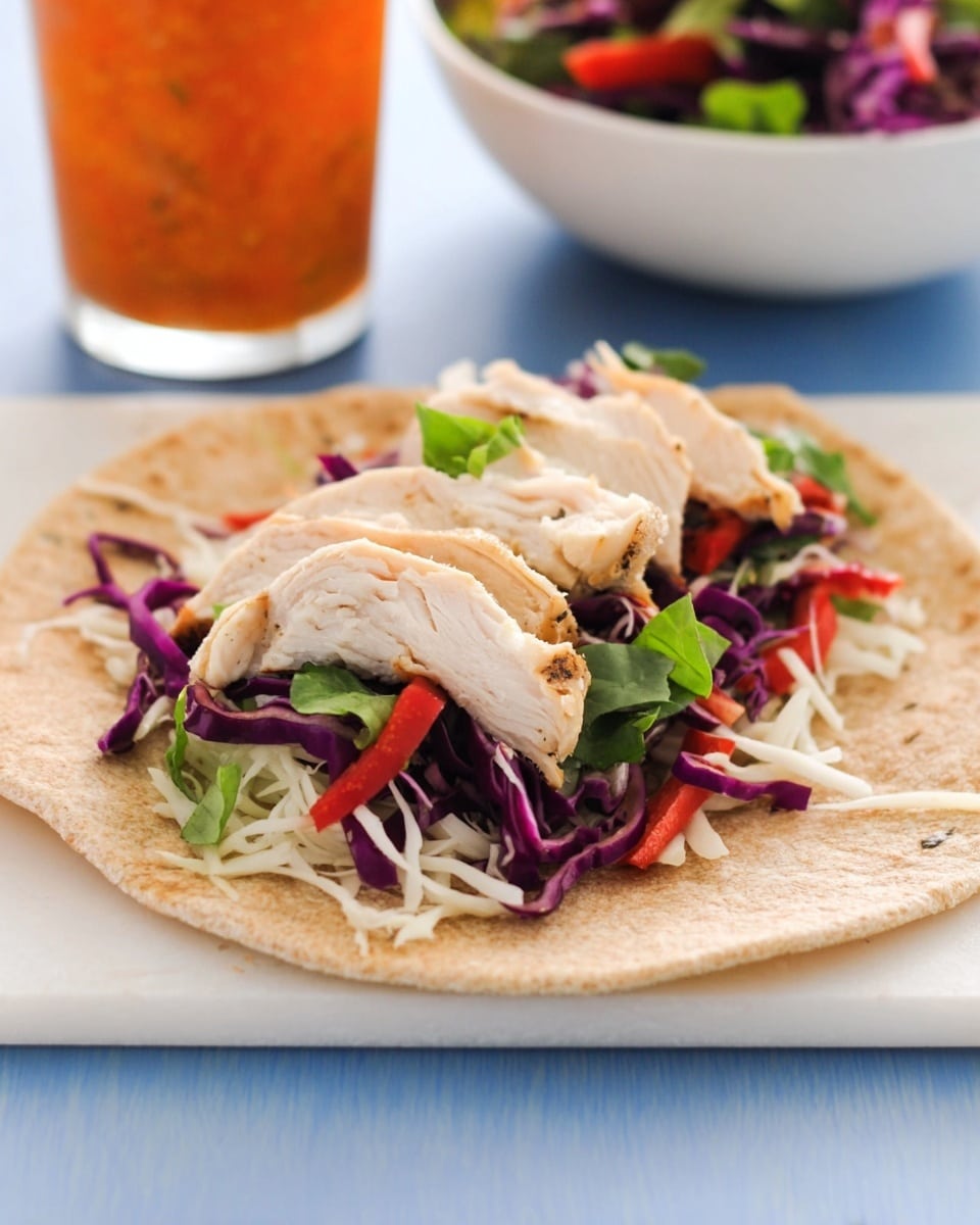 A round whole wheat tortilla lies flat on a white marbled surface with layered fillings placed in the center. The bottom layer has thin white shredded cheese, topped with bright purple shredded cabbage mixed with finely chopped green herbs and thin slices of red bell pepper. Over this, there are slices of white cooked chicken arranged in a line across the vegetables. In the blurred background, a glass with orange sauce and a white bowl filled with a purple and green mixed vegetable salad are visible. Photo taken with an iphone --ar 4:5 --v 7