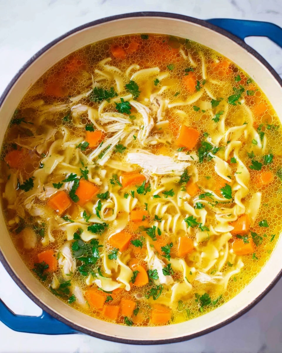 A white pot filled with chicken noodle soup showing three main layers: a clear yellow broth base with small bubbles, a middle layer of orange carrot cubes and white onion pieces, and a top layer of pale yellow curly egg noodles mixed with shredded white chicken pieces and scattered green parsley leaves, all sitting on a white marbled surface photo taken with an iphone --ar 4:5 --v 7