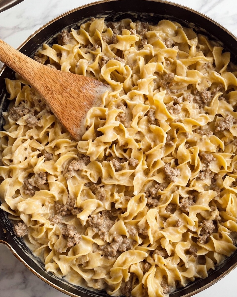 The dish is a layered casserole in a clear glass round dish sitting on a white marbled surface. The bottom layer is a light yellow cabbage that looks soft and slightly cooked. Above that is a layer of ground meat mixed with chunks of red tomatoes, creating a rough texture with brown and red colors. On top of the meat layer, there is more cabbage, lighter in color with a soft texture. The top layer is melted cheddar cheese, a bright orange-yellow color with some browned, crispy spots. There are small green parsley leaves spread over the cheese for garnish. The photo is close up, showing the different layers clearly, with soft lighting highlighting the melted cheese. photo taken with an iphone --ar 4:5 --v 7