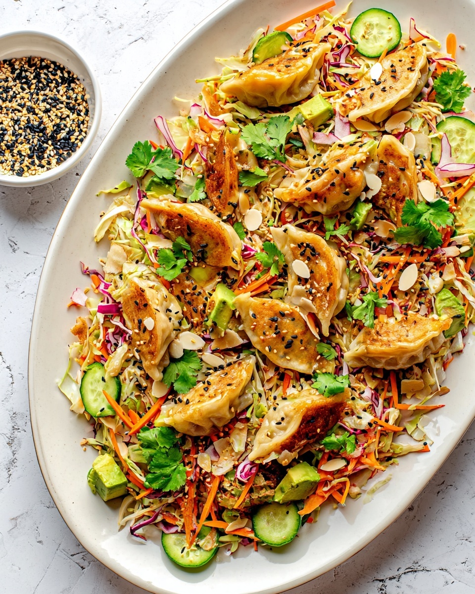 The image shows a white oval plate filled with a colorful dish. On the bottom layer, there is shredded light yellow cabbage mixed with thin orange carrot strips and thin slices of red onion. Scattered over this are bright green cucumber slices and chunks of avocado cubes. On top of this vegetable mix, there are several golden-brown pan-cooked dumplings arranged unevenly. The dish is garnished with some fresh green cilantro leaves, pale almond slices, and sprinkled with black sesame seeds. To the side, there is a small white bowl with a mix of black and white sesame seeds. The plate sits on a white marbled surface. Photo taken with an iphone --ar 4:5 --v 7