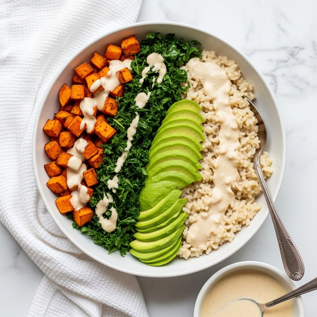 A bowl with four layers arranged side by side is shown. The first layer on the left is dark green kale with a fresh texture. Next to it are green avocado slices fanned out smoothly. On the right is a layer of white rice with a light and fluffy texture. In front of the avocado and rice, there are pieces of browned chicken and a layer of orange roasted sweet potatoes with a slightly rough texture. The whole bowl is drizzled with a light pink creamy sauce and sprinkled with white crumbled cheese. A silver spoon rests inside the rice layer. The bowl is white with a brown rim, set on a white marbled surface. Photo taken with an iphone --ar 4:5 --v 7