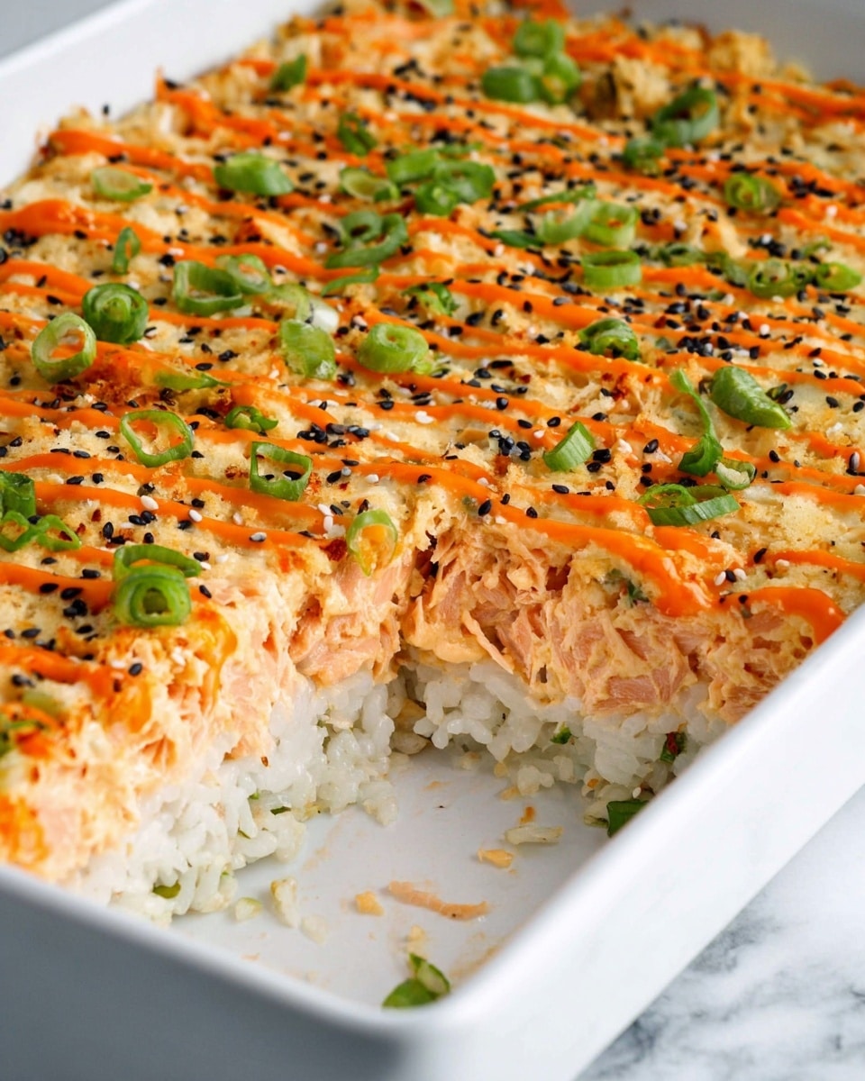 This image shows a layered sushi casserole in a white rectangular dish placed on a white marbled surface. The bottom layer is white rice with visible small green bits mixed in. The middle layer is creamy, light orange with shredded pieces of salmon mixed in. The top layer is made of bright orange drizzle sauce with green chopped scallions and a sprinkle of black and white sesame seeds. A portion of the casserole has been removed, showing clear clean layers and texture. photo taken with an iphone --ar 4:5 --v 7