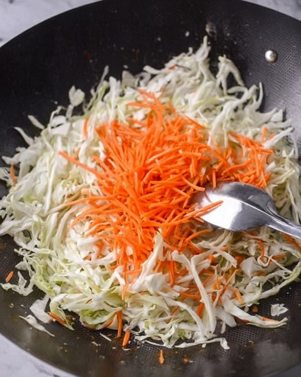A large black wok shows a layer of thinly sliced white cabbage spread evenly on the bottom, with bright orange thin carrot strips placed in a small pile near the center. A shiny metal spoon is resting on the carrot layer, slightly pushing some carrots and cabbage. The background is a white marbled surface. photo taken with an iphone --ar 4:5 --v 7