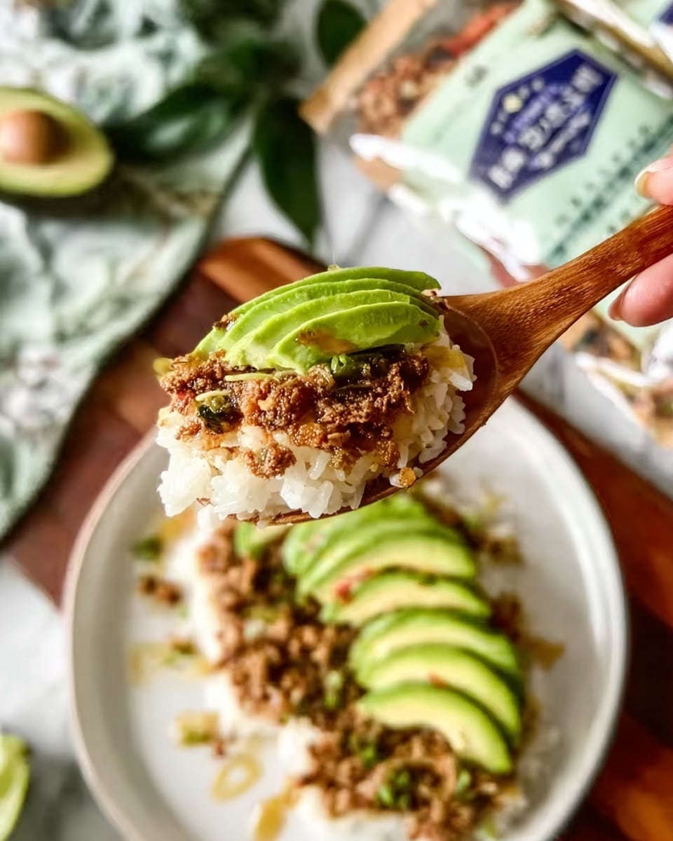 The image shows a close-up of a wooden spoon holding a bite of food with layers: white rice at the bottom, topped with a brown crumbly layer and a thin slice of green avocado on top. In the background, on a white marbled surface, there is a white plate with more of the same dish, arranged with avocado slices on top and light drizzle across it. Some green leaves and food packages are blurred in the distant background. A woman's hand holds the spoon from the upper right corner. Photo taken with an iphone --ar 4:5 --v 7