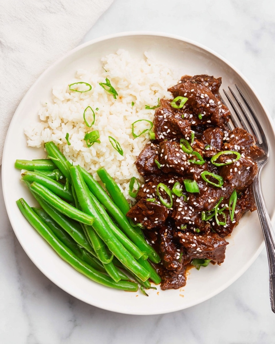 A white plate on a white marbled surface holds three main layers: at the bottom is a layer of plain white rice covering half the plate; on one side, a neat pile of bright green steamed green beans with a smooth texture, and on the other side, tender dark brown meat covered in a glossy sauce, sprinkled with white sesame seeds and small chopped green onions. A silver fork rests on the edge of the plate. The lighting is bright and natural. photo taken with an iphone --ar 4:5 --v 7