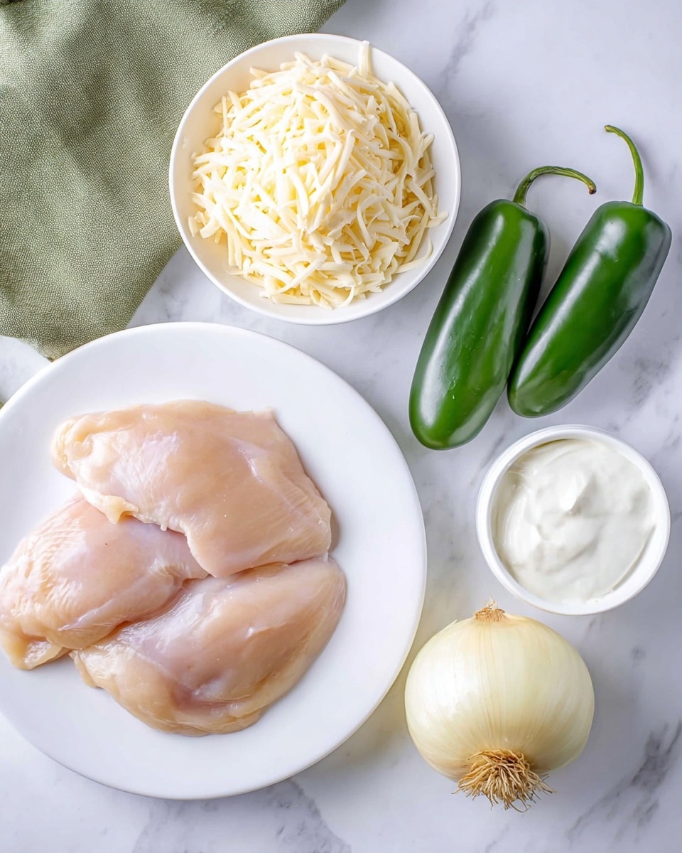 The image shows three raw chicken pieces on a large white plate in the bottom left. Above the plate, there is a small white bowl filled with a heap of shredded cheese that is pale yellow in color. To the right of the cheese bowl, there are three whole green jalapeno peppers with smooth, shiny skin resting naturally on a white marbled surface. Below the peppers, slightly to the right, there is a white container filled with creamy white sour cream. In the bottom right corner, there is a quarter of a yellow onion with visible layers and roots. A green cloth napkin peeks from the left side near the chicken plate. The whole setup is on a bright white marbled surface. photo taken with an iphone --ar 4:5 --v 7