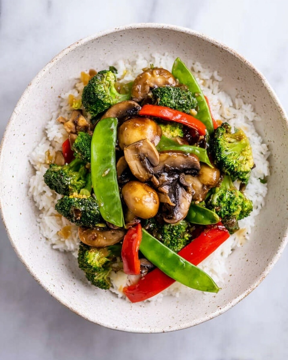 A white speckled bowl filled with a base layer of white rice, topped with a colorful mix of vegetables including bright green broccoli florets, light brown sliced water chestnuts, dark brown sautéed mushrooms, fresh green snap peas, and bright red bell pepper strips. The vegetables appear cooked but still vibrant, placed evenly over the rice showing their different textures crisp, smooth, and slightly shiny from a light sauce. The bowl is set on a white marbled surface. photo taken with an iphone --ar 4:5 --v 7