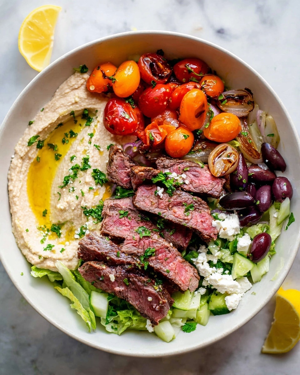 The dish is served in a white bowl on a white marbled texture surface. The base layer is light green chopped lettuce covering the bottom. On the left side, there is a smooth, creamy beige hummus spread with a drizzle of golden olive oil on top. Around the hummus are roasted cherry tomatoes in bright orange and red, along with grilled onion pieces that have light char marks. Near the middle to right side, slices of medium-rare steak with a pink center and seared brown edges are neatly placed, garnished with chopped fresh green herbs. There are also dark purple kalamata olives scattered among diced light green cucumber pieces and small white crumbles of feta cheese, with a lemon wedge sitting near the bottom right edge. The fresh herbs add small bursts of green across the whole dish. photo taken with an iphone --ar 4:5 --v 7