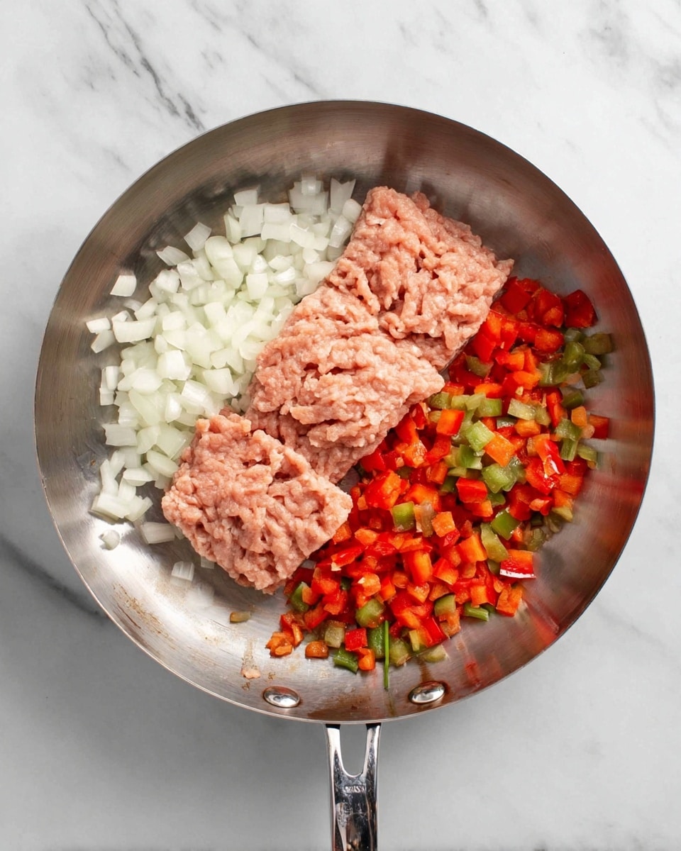 A shiny silver pan sits on a white marbled surface, containing two thick, even layers of light pink ground meat placed side by side. On the left side of the pan, there are diced white onions with small pieces scattered around. Below the onions, diced red bell peppers and small bits of green peppers add bright color to the mix. The vegetables and meat are separate but close in the pan. Photo taken with an iphone --ar 4:5 --v 7