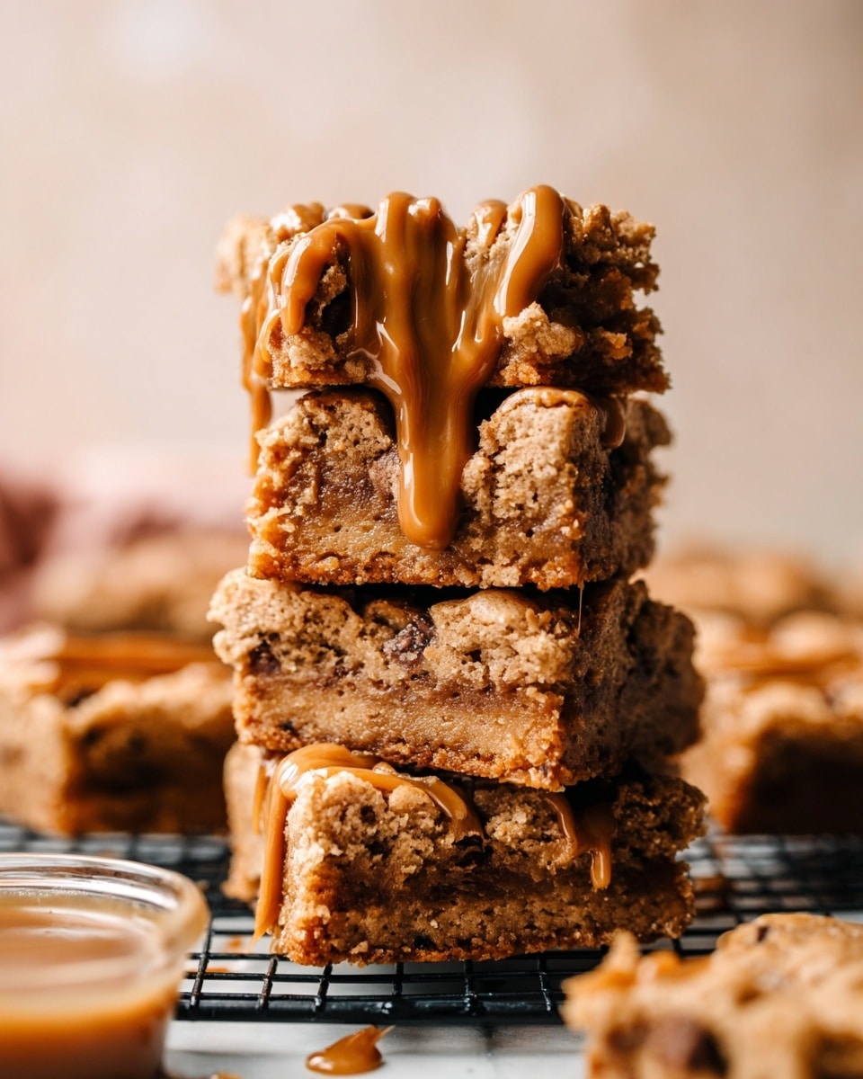 A tall stack of four thick square cookie bars with a crumbly texture is shown, each bar light brown with visible chocolate pieces inside. The bars are dripping with smooth caramel sauce that flows down the sides unevenly, adding a glossy look. The stack is centered on a black wire cooling rack set on a white marbled surface. In the out-of-focus background, there are more cookie bars and a small container filled with caramel or a similar sauce. The lighting is soft, warm, and natural, highlighting the texture and shine of the caramel. photo taken with an iphone --ar 4:5 --v 7