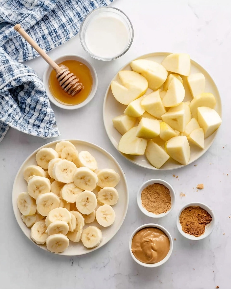 The image shows two white plates on a white marbled surface, one full of pale yellow apple pieces with smooth texture and the other with round slices of soft banana in light cream color. Near these plates, there are small white bowls containing golden honey with a wooden dipper, light brown cinnamon powder, and light brown peanut butter with a creamy texture. A clear glass cup with white liquid is placed near the smaller white bowls. A checkered blue and white cloth lies to the side, adding a soft touch to the scene. Photo taken with an iphone --ar 4:5 --v 7