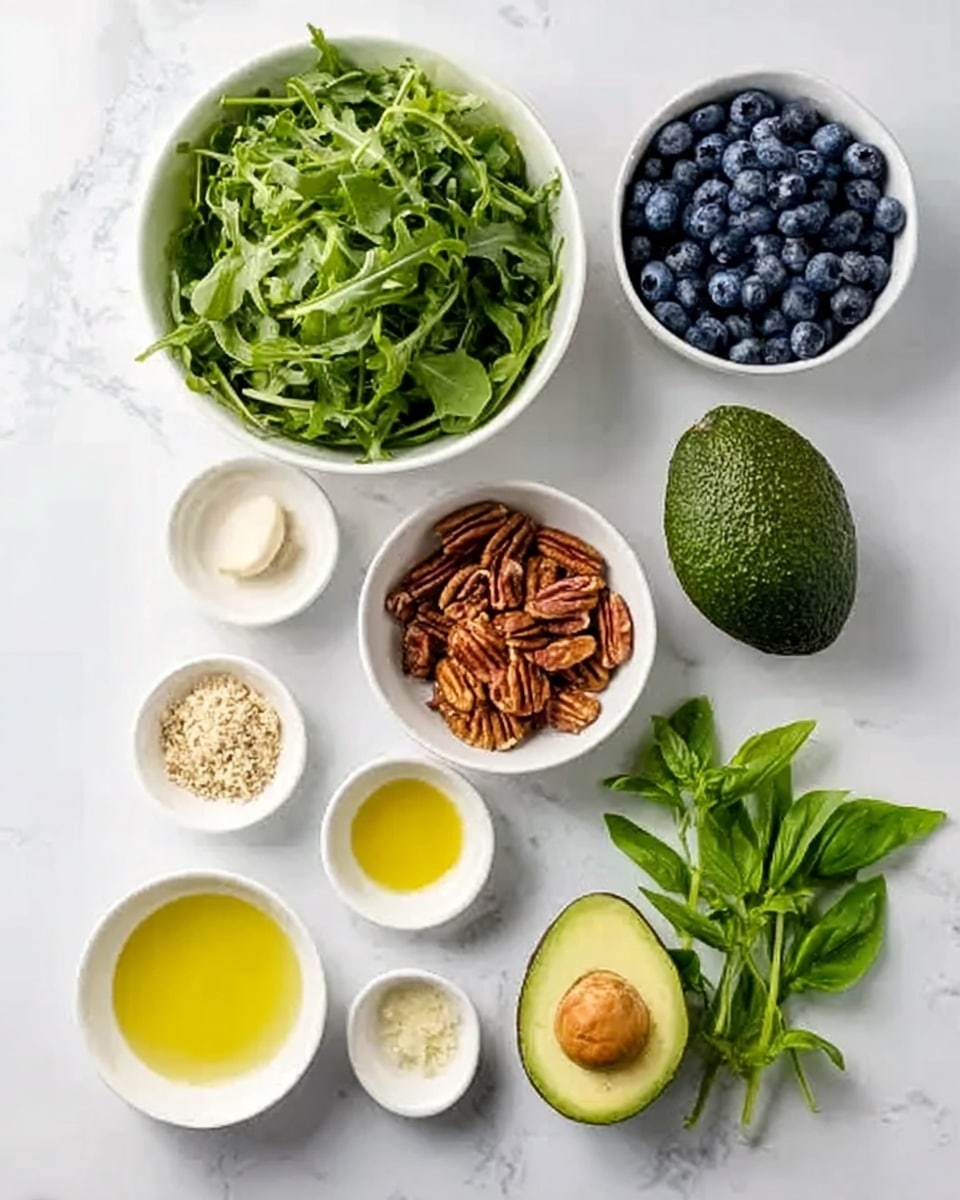The image shows several small white bowls and a whole avocado placed on a white marbled surface, arranged neatly in a flat lay style. One large white bowl at the top left is filled with bright green leafy arugula. To its right, a smaller white bowl is full of deep blue blueberries. Below those, a white bowl contains brown pecans with a slightly shiny texture. Another white bowl nearby holds a crumbly light beige substance. There are four small white bowls arranged near the bottom: one with golden olive oil, one with a light yellow liquid, one with a single garlic clove, and one with a pale yellow dollop of mustard. Finally, a small bunch of fresh green basil leaves with smooth texture is placed to the bottom right. A ripe, dark green avocado with smooth skin sits near the center left. The clean and fresh arrangement on the white marbled surface shows each ingredient clearly. photo taken with an iphone --ar 4:5 --v 7