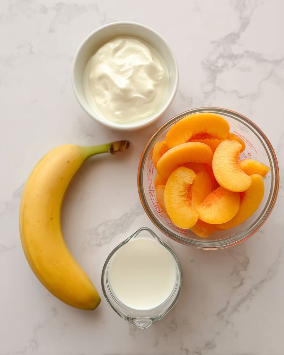 The image shows four ingredients placed on a white marbled surface: a glass measuring cup filled with bright orange peach slices at the top right, a white round bowl containing a creamy white substance at the top left, a ripe yellow banana positioned diagonally on the left side, and a smaller glass measuring cup with a white liquid, likely milk, at the bottom center. All items are neatly arranged and viewed from above, creating a clean and simple presentation photo taken with an iphone --ar 4:5 --v 7